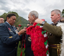 Chief of New Zealand Army Major General John Boswell (right) places our Ngā Tapuwae kahu huruhuru on the last surviving member of B Company, Robert Gillies 2019. A member of the RNZAF assists in the tie on a cloudy day. 