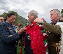 Chief of New Zealand Army Major General John Boswell (right) places our Ngā Tapuwae kahu huruhuru on the last surviving member of B Company, Robert Gillies 2019. A member of the RNZAF assists in the tie on a cloudy day.