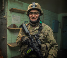 Corporal Nori Lee smiles at the camera, fully equipped in operational gear.