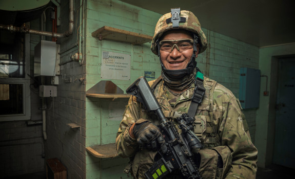Corporal Nori Lee smiles at the camera, fully equipped in operational gear.