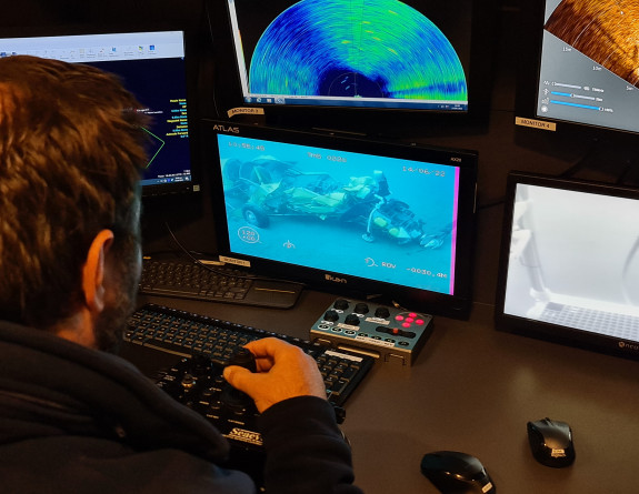 The Ship's crew look at the plane on the seabed using a remotely operated vehicle in the ocean and a video feed is sent back to the ship.