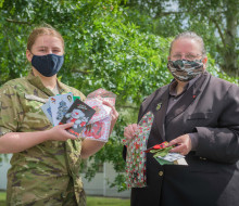 Dellwyn Moylan and Private Caitlin Candy hold up items which will be packed inside Christmas packages for personnel.