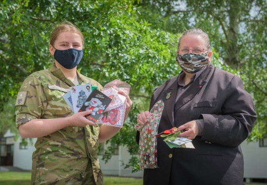 Dellwyn Moylan and Private Caitlin Candy hold up items which will be packed inside Christmas packages for personnel.