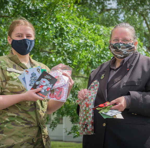 Dellwyn Moylan and Private Caitlin Candy hold up items which will be packed inside Christmas packages for personnel.