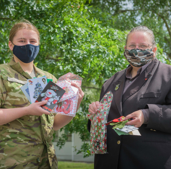 Dellwyn Moylan and Private Caitlin Candy hold up items which will be packed inside Christmas packages for personnel.
