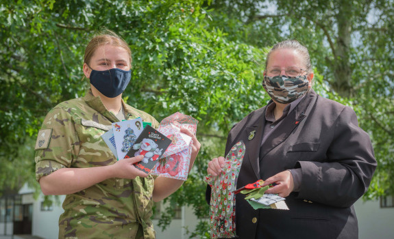 Dellwyn Moylan and Private Caitlin Candy hold up items which will be packed inside Christmas packages for personnel.