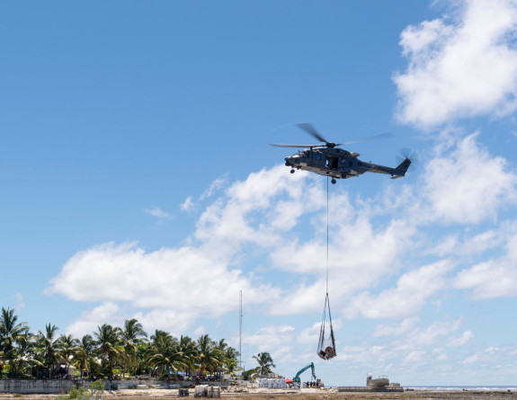 An NH90 helicopter and aircrew from No. 3 Squadron carrying a load to Tokelau