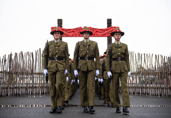 New Zealand Army recruits march in formation through the arch with Māori carvings and onto the parade ground in Waiouru on graduation day