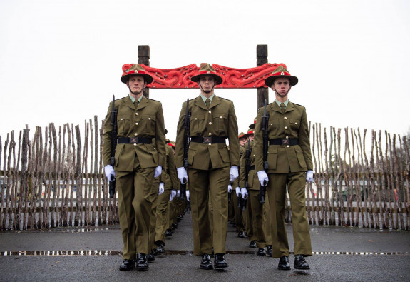 New Zealand Army recruits march in formation through the arch with Māori carvings and onto the parade ground in Waiouru on graduation day