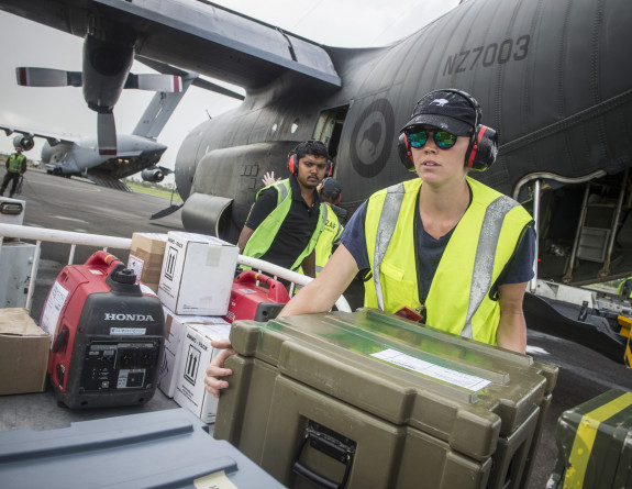 Members of the RNZAF Air Load Team unload aid and cargo from a C-130 Hercules at Nausori following Tropical Cyclone Winston in Fiji.