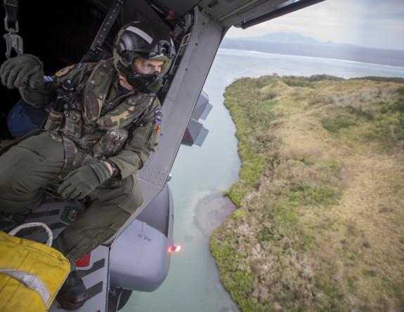 A Helicopter Loadmaster looks over the landing zone from a NH90 Helicopter as it comes in to land to deliver personnel and aid. The NZDF has deployed to Fiji to provide Humanitarian Aid and Disaster Relief following Tropical Cyclone Winston.