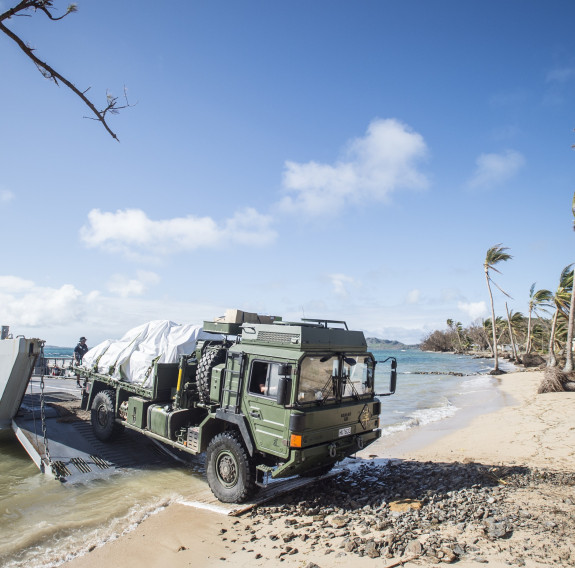Army personnel and a Medium to Heavy Operation Vehicle are unloaded off an Landing Craft Mechanism from HMNZS Canterbury in Fiji.
