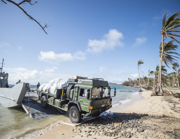 Medium Heavy Operation Vehicle driving off of Landing Craft Mechanism and onto the beach on Fiji. 