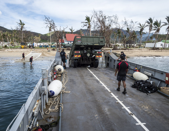 An empty Medium Heavy Operational Vehicle (MHOV) is driven on to a Landing craft at Vanua Balavu Island in Fiji, for transport back to HMNZS Canterbury.