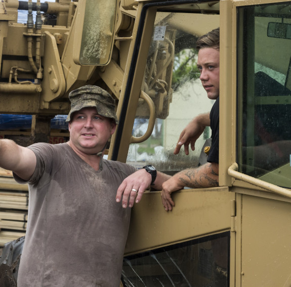 CPL Lochlann Murphy (left) converses with MATBRO driver PTE Ricky Scott (right) during movement operations at the New Zealand Defence Force Forward Operating Base at Lomaloma. The NZDF deployed to Fiji to provide Humanitarian Aid and Disaster Relief follo