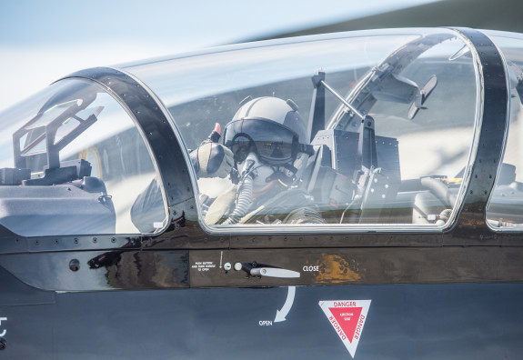 A pilot giving a thumbs up while inside the flight deck of a Texan aircraft