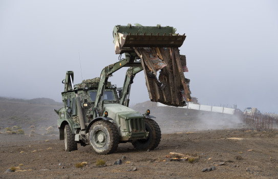 A tractor helps to clear debris in order to make room for new sangars to be built in the Waiouru training area.