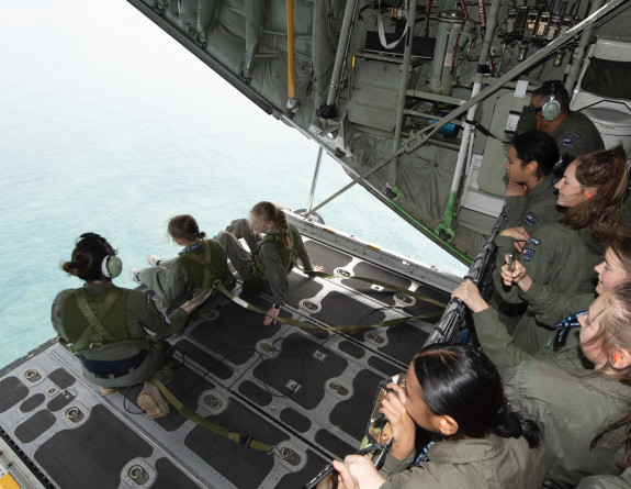 School to Skies participants sit on the ramp of a C-130H(NZ) Hercules while supervised by a Loadmaster
