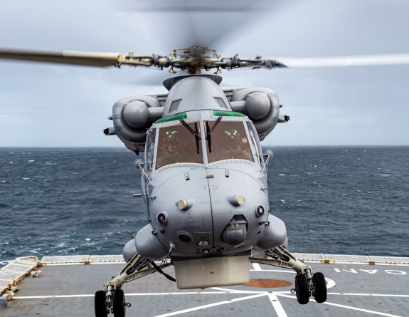 A Seasprite helicopter hovering over a flight deck on a ship 