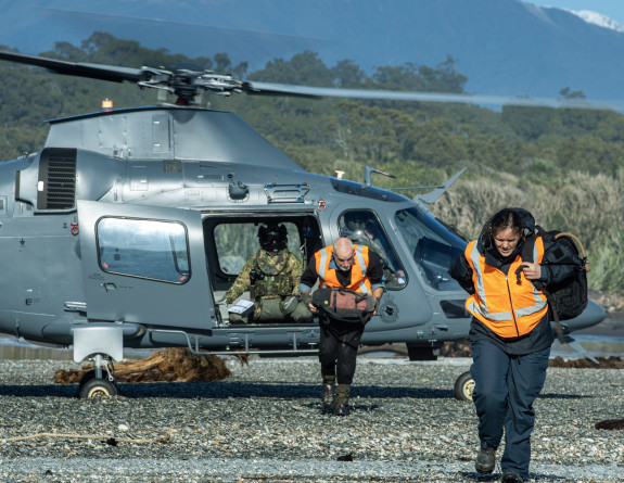 Personnel disembarking from an NH90 helicopter at river near Fox Glacier