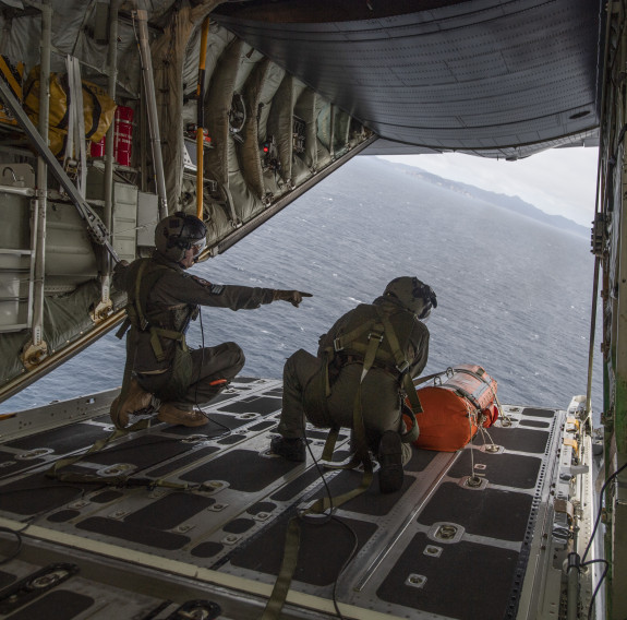 C-130H(NZ) Hercules Loadmasters conduct air drops as they fly over the drop zone for a search and rescue exercise. 