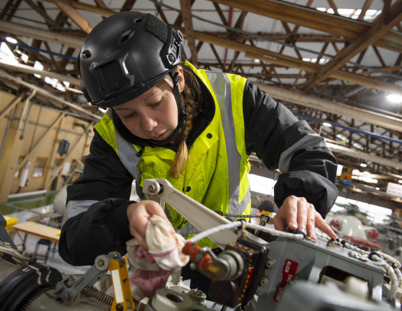 An Aircraft Technician performs maintenance checks on the rotorhead of a SH-2G(I) Seasprite helicopter air frame during Exercise Bluebird at Base Woodbourne.