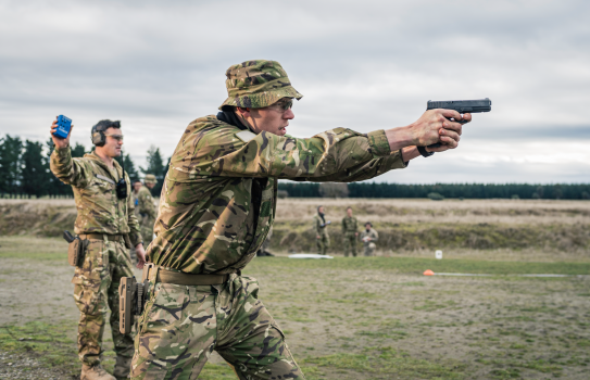 A soldier fires a glock on a weapons range