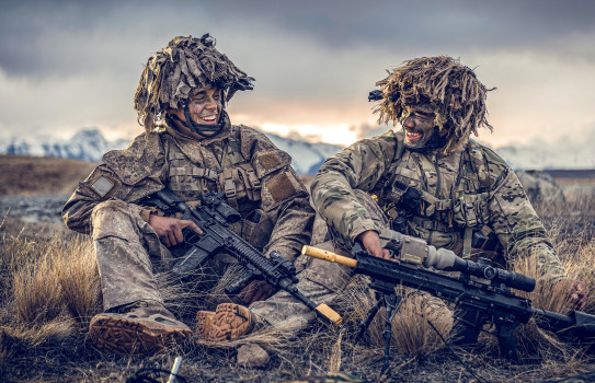 Two soldiers smiling at each other while sitting down in the Waiouru Military Training Area