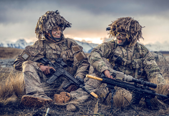 Two soldiers smiling at each other while sitting down in the Waiouru Military Training Area
