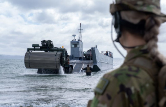 An NZ Army soldier looks out into the sea during as an NZDF Landing Craft (Mechanised) makes its way to shore during an exercise