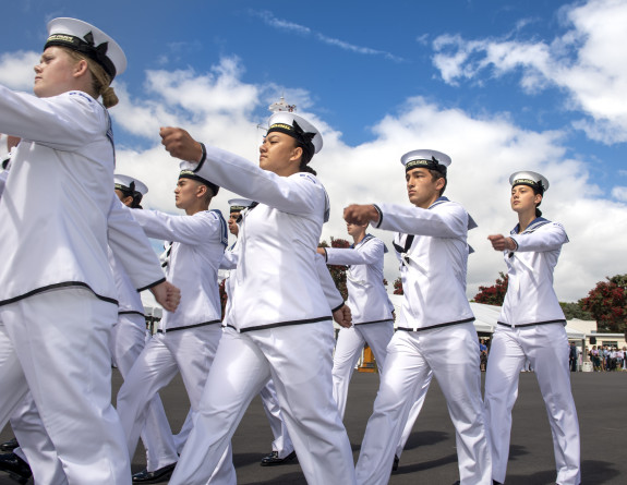 Navy sailors march in formation on the parade ground on a nice day