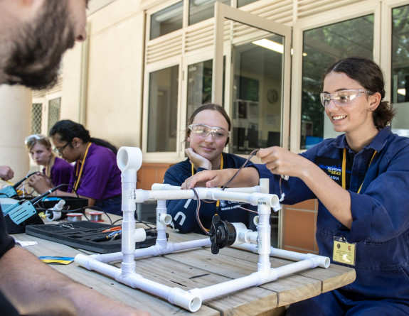 Two School to Seas participants work together in building a remote underwater robot 