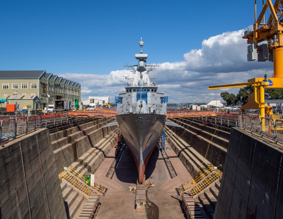 A bow of a Navy ship in the dry dock at Devonport Naval base on a sunny day