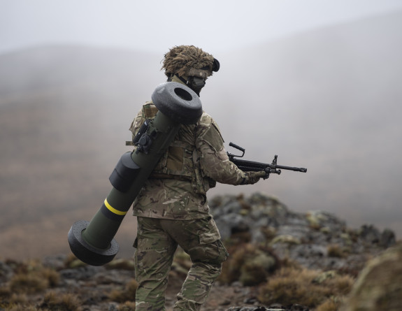 A New Zealand Army soldier carries a Javelin Medium Range Anti Armour Weapon (MRAAW) on their back while walking on unforgiving terrain and weather conditions in the Waiouru Military Training Area 