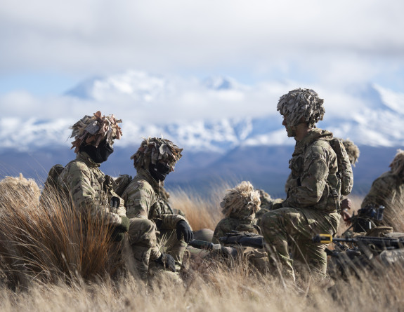 A group of New Zealand Army recruits group together within the tussock of the Waiouru Military Training Area with the Mt Ruapehu in the background