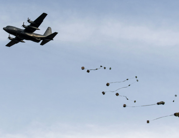A Royal New Zealand Air Force C-130H(NZ) Hercules aircraft air drops loads onto a drop zone at Raumai Range