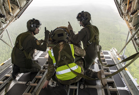 Loadmasters on board a Royal New Zealand Air Force C-130H(NZ) Hercules aircraft prepare to drop a load onto a dropzone. 