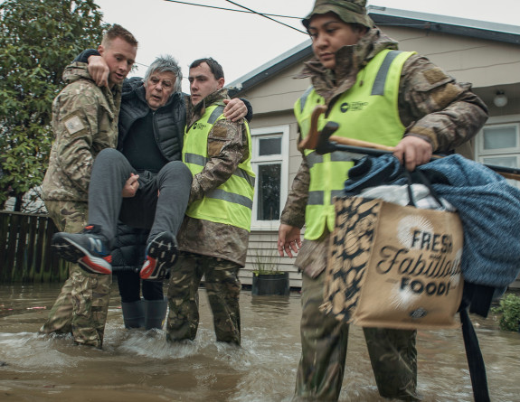 Soldiers from 3rd Combat Service Support Battlion (3CSSB) assist a Buller District resident evacuate from their home following flooding.