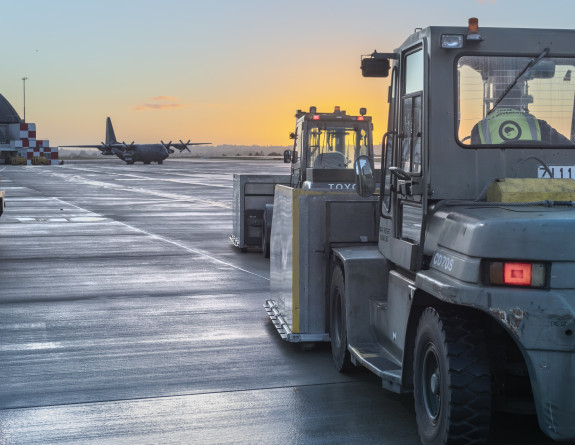 Forklifts loaded with equipment waits for the order to load onto the Royal New Zealand Air Force C-130H(NZ) Hercules aircraft.