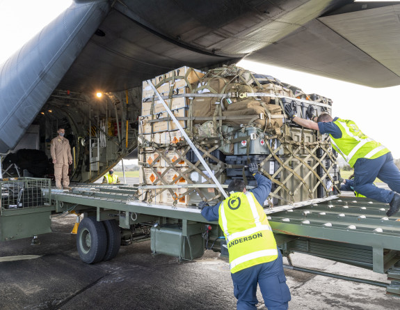 Ground crew push a pallet containing military equipment onto the Royal New Zealand Air Force C-130H(NZ) Hercules aircraft. Five pallets in total were loaded. 