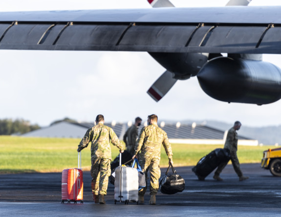 Aircrew carrying luggage head to the Royal New Zealand Air Force C-130H(NZ) Hercules 