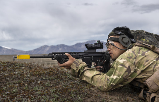 Lance Corporal Se Won Kim lies down in the Tekapo landscape, aiming a weapon into the distance.
