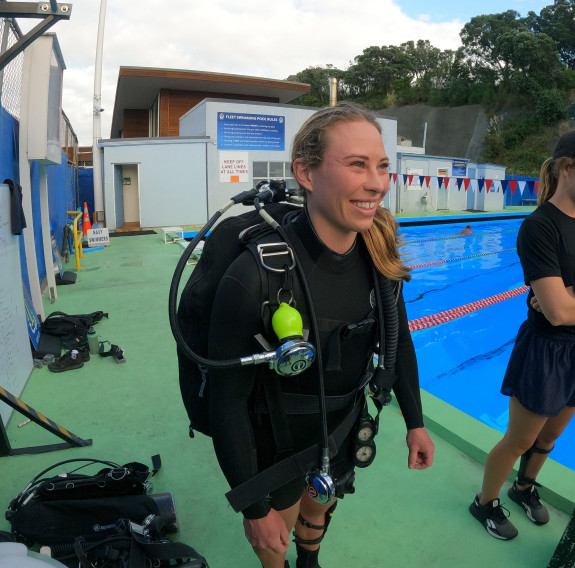 Katrina Koch-Underhill (left) and Sarah Gunderson (right) standing poolside during dive training drills at Devonport Naval Base.