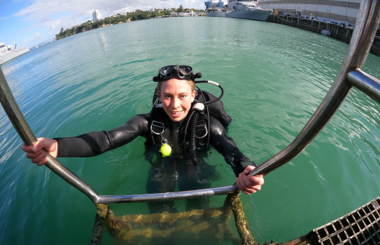 Sailor First Class (Diver) Katrina Koch-Underhill climbing out of the water in dive apparatus at Davenport Naval Base.