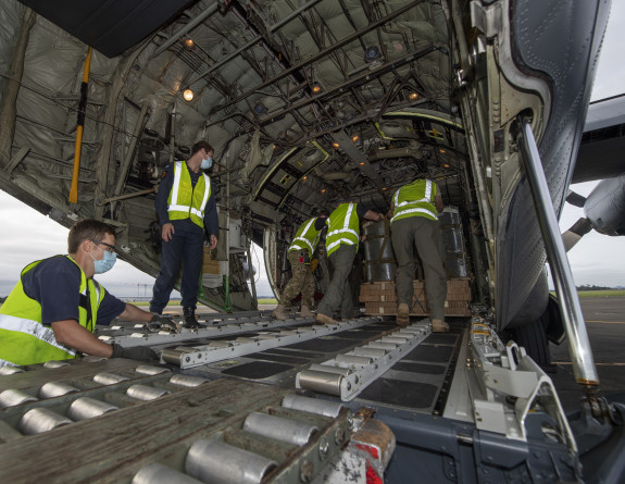 Personnel loading pallets into the back of the Hercules aircraft.