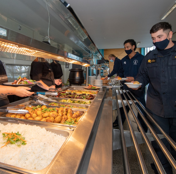 Lunch is served and sailors choose their hot food options from the heated buffet-style cabinet in the Vince McGlone Gallery.