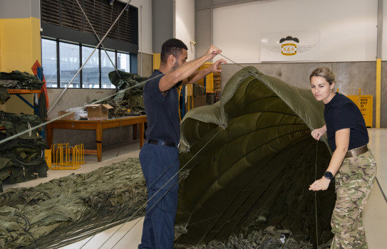 Safety and Surface personnel check over parachutes after an exercise