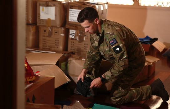 New Zealand Army's Lieutenant Ben Sinclair sorts through equipment donated by New Zealand soccer clubs to the Iumi Play Programme in Solomon Islands.