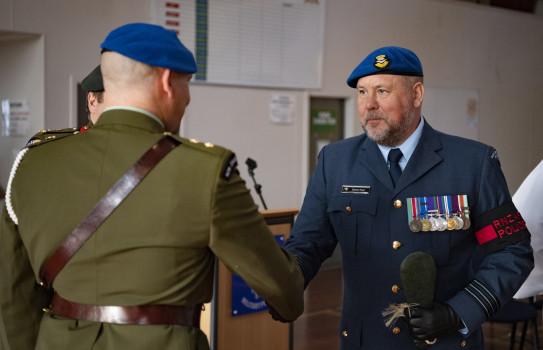 Military Police Change of Command at Trentham Military Camp - two personnel shake hands, one with their back to the camera, the other facing toward camera. 