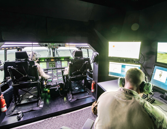 The Royal New Zealand Air Force NH90 simulator - two personnel in the flight deck seats and one sitting in behind.